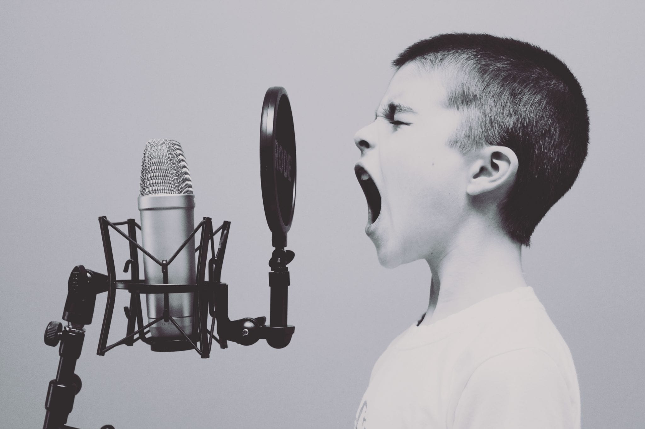 risks of not testing software properly represented by boy shouting into a microphone