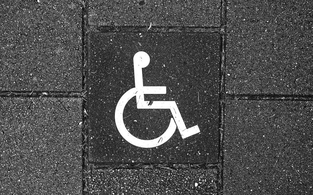 Software Accessibility represented by wheelchair sign on sidewalk