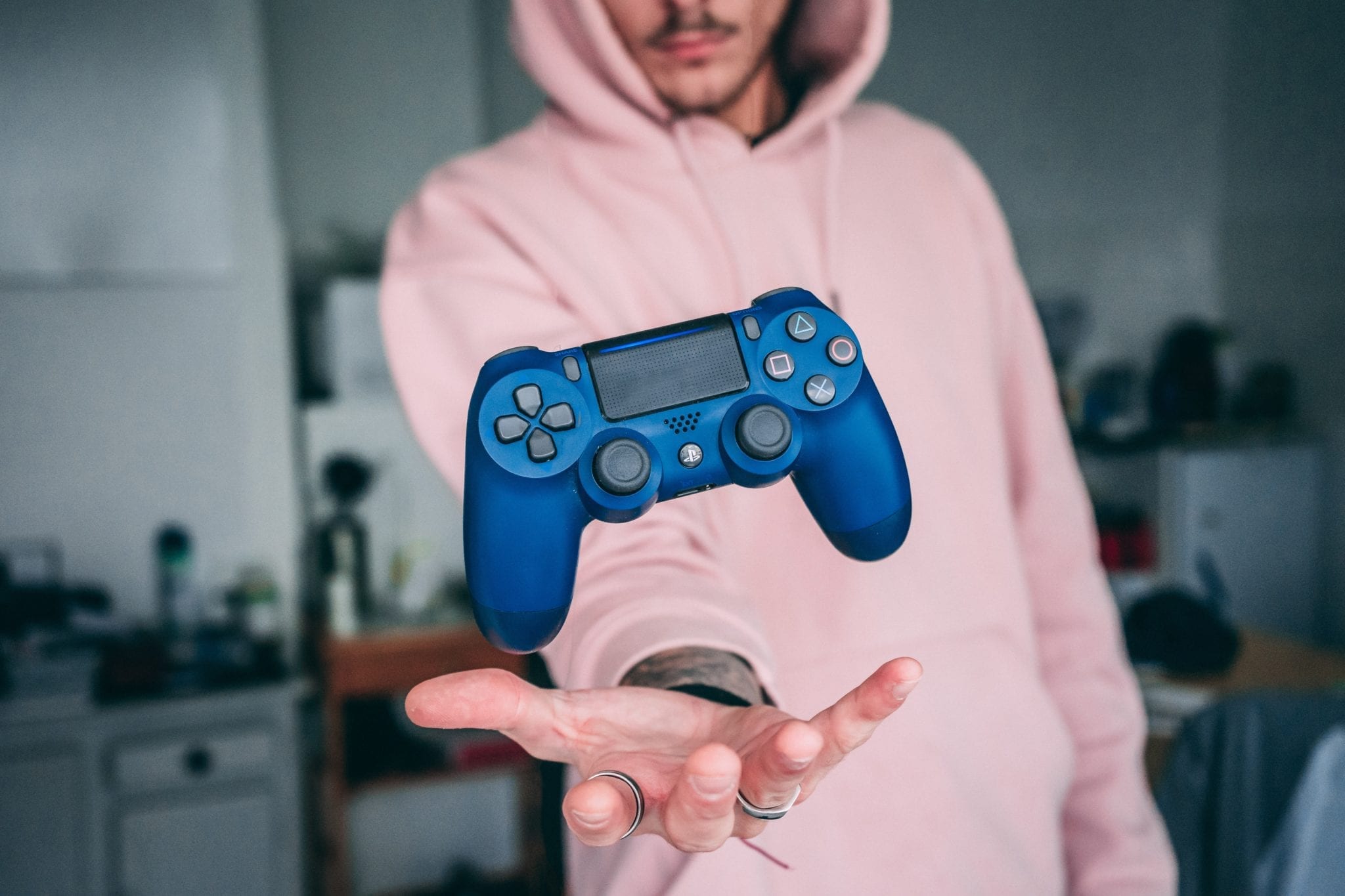 gaming represented by man holding a floating video game controller