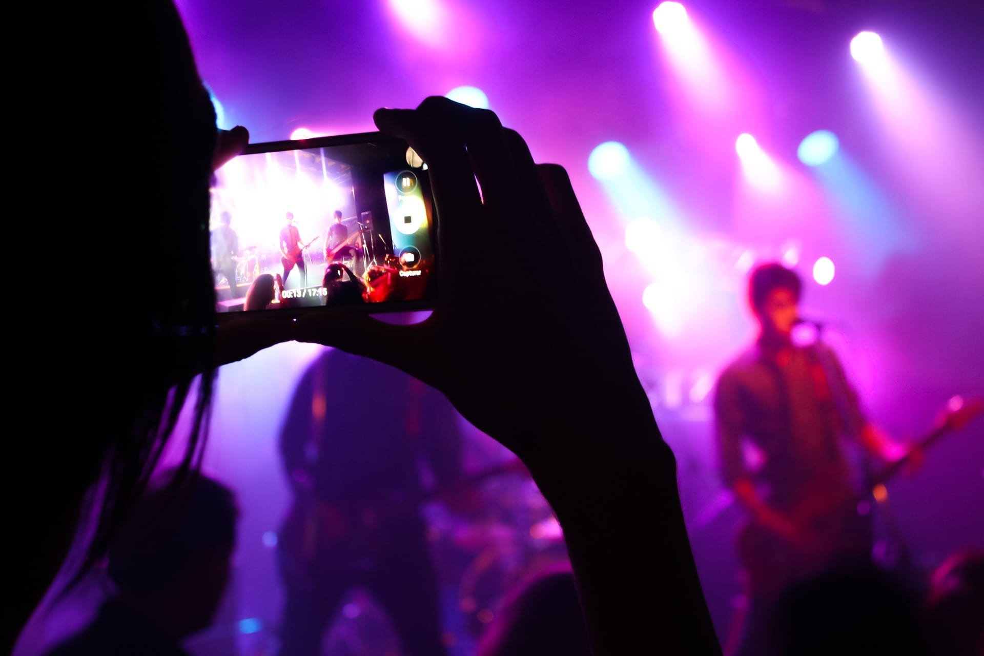 go-live performance testing represented by man holding cell phone to record live music performance